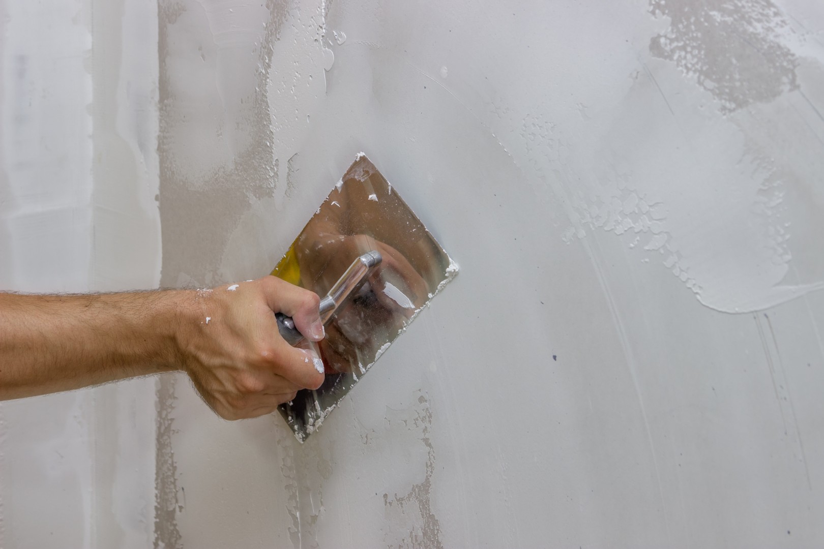 man hand with trowel plastering a wall 3